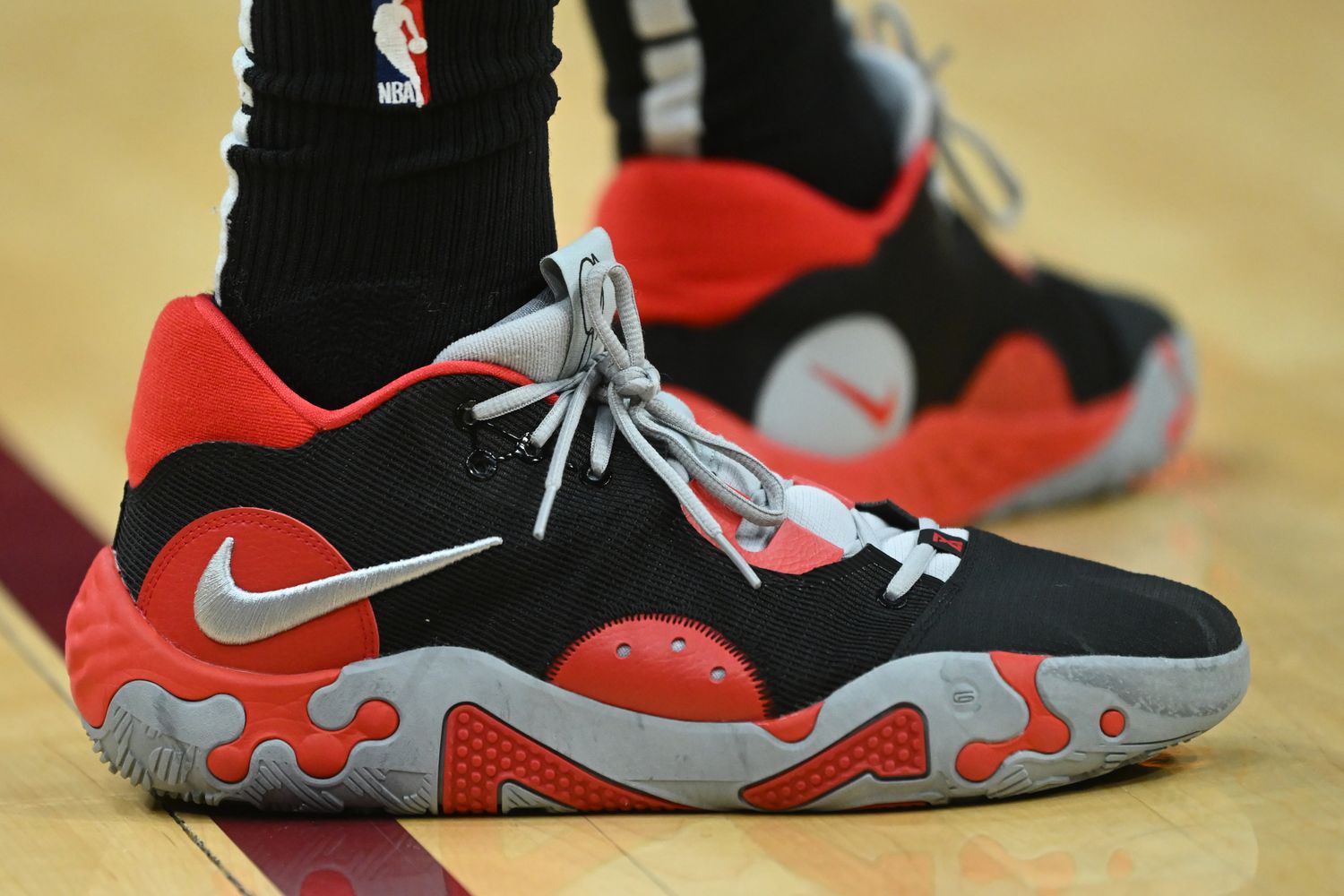 View of black, red, and grey Nike PG shoes.
